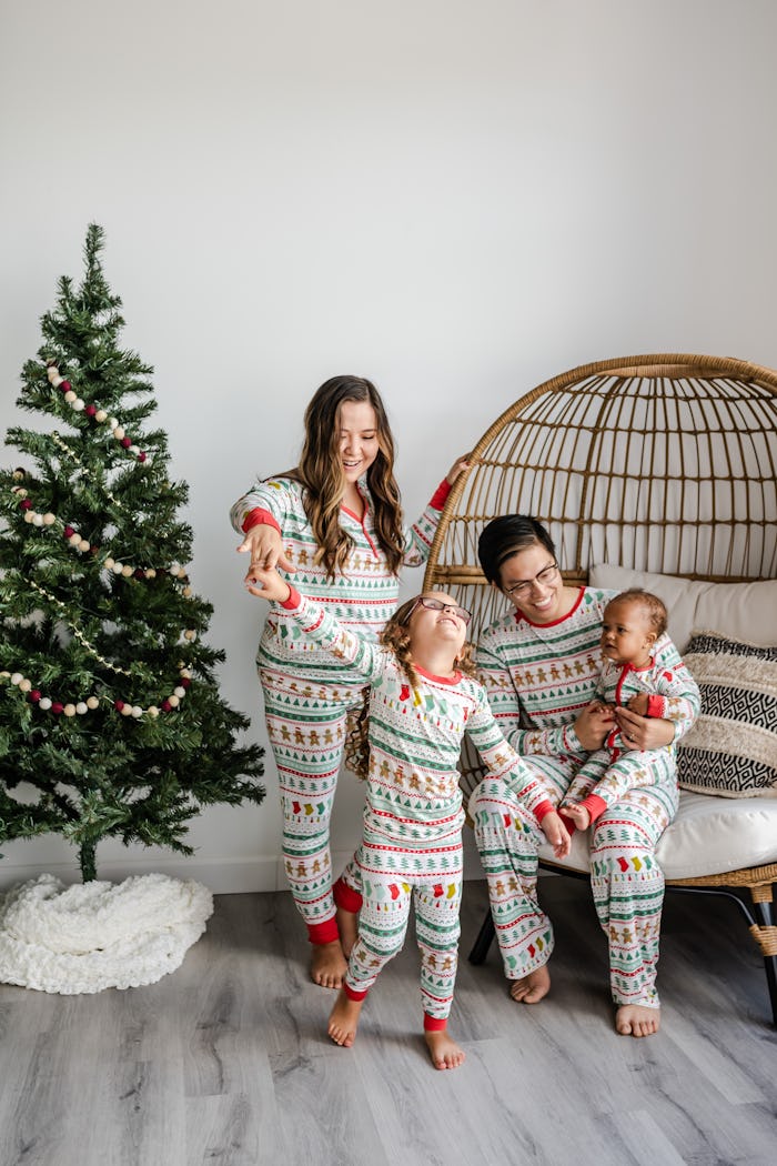A family in festive long johns in front of a Charlie Brown Christmas tree. 