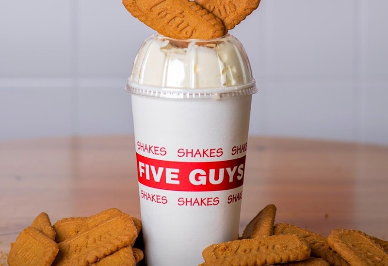 A five guys Biscoff milkshake with lotus biscuits on top and around the base