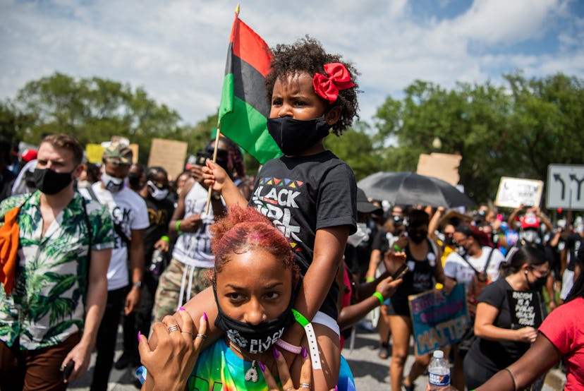 A little girl rest on her mother's shoulders, as demonstrators walk from the Lincoln Memorial to the...