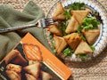 Trader Joe's Spicy Pumpkin Samosas sit on a colorful plate during the fall.