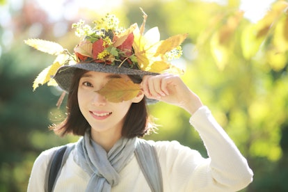 Young woman holding fall leaf