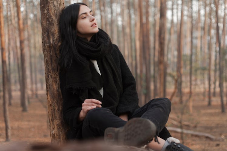 Young woman sitting on tree