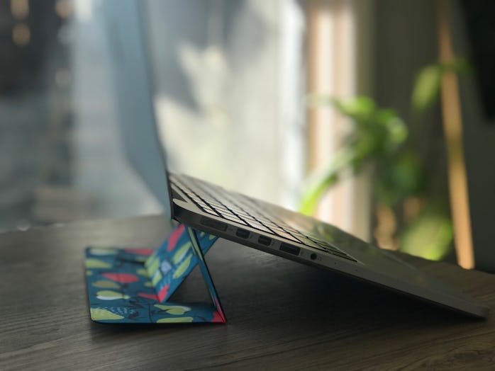 A side photo of the Moft laptop stand on a dining table. The background shows glass window for a pat...