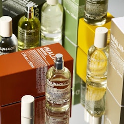 Men's grooming products, including oils stacked on a glass table
