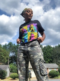 Jordan Kristine Seamón in a Tupac inspired T-shirt and Cargo pants under the cloudy sky.