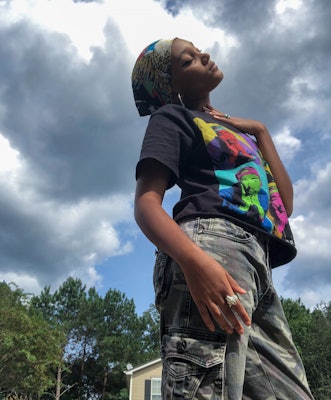 Jordan Kristine Seamón in a Tupac inspired T-shirt and Cargo pants under the cloudy sky with her eye...