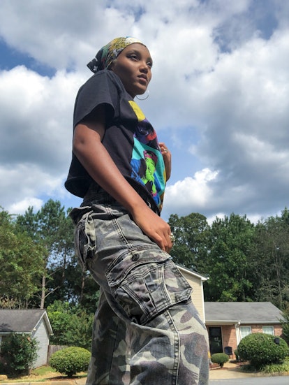 Jordan Kristine Seamón in a Tupac inspired T-shirt and Cargo pants under the cloudy sky looking some...