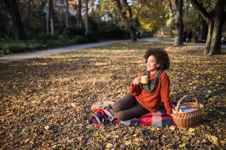 Young woman drinking coffee in fall