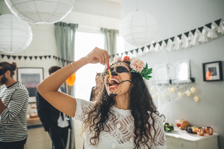 Young woman eating gummy worm on Halloween