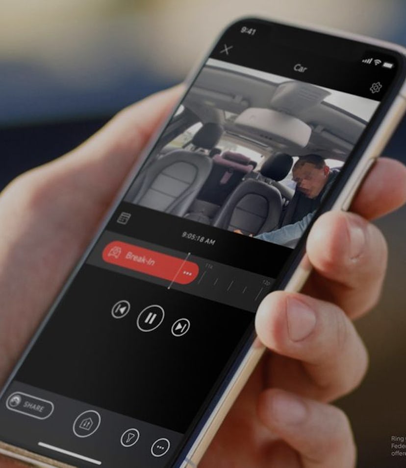 A close-up of a smartphone in a person hand, displaying a video of a person entering a car.