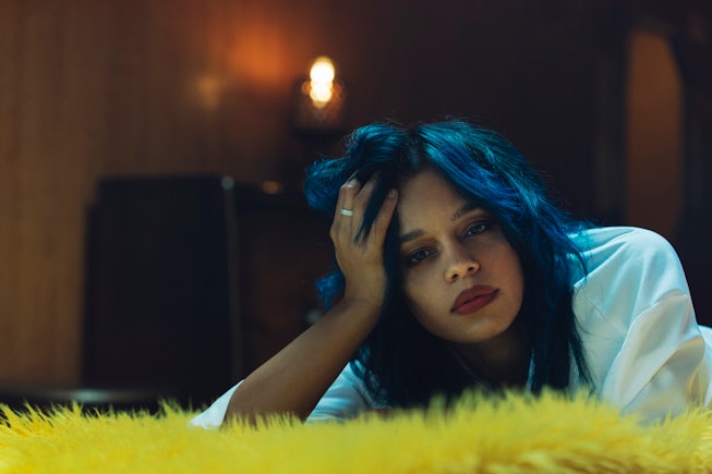 Fefe Dobson with blue hair with a head leaned on her right hand
