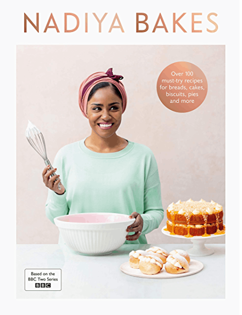Nadiya hussein pictured on the cover of nadiya bakes wearing a mint green top, pink and purple head-...
