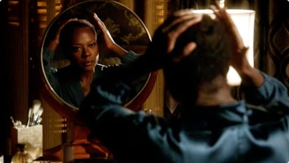 Viola Davis looking into a mirror and fixing her hairstyle