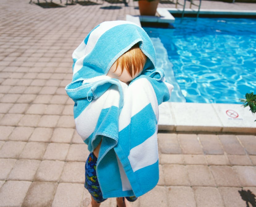 child hiding behind towel