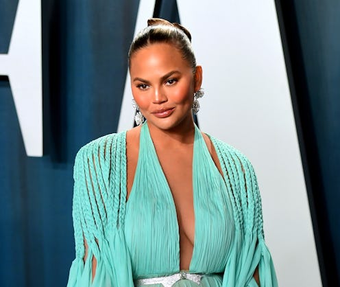 Chrissy Teigen pictured on the red carpet wearing a Tiffany blue dress with a diamond belt