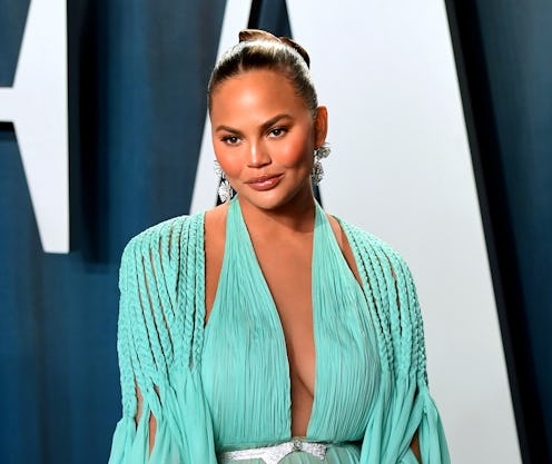 Chrissy Teigen pictured on the red carpet wearing a Tiffany blue dress with a diamond belt