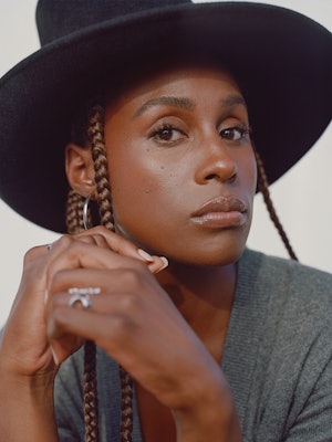 Issa Rae posing in an Alexander Wang grey top and black Gucci hat, Ben Oni earrings and a Third Crow...