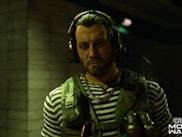 Character from Call of Duty: Modern Warfare wearing headphones in a dark room