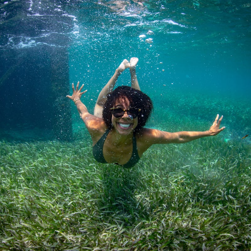 Ayana Elizabeth Johnson diving at the bottom of a sea wearing a black bikini and goggles
