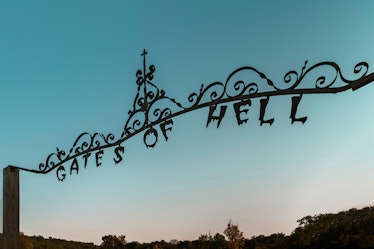 The entrance to the "Mayor of Hell" listing on Airbnb reads, "Gates of Hell" as the sun sets.