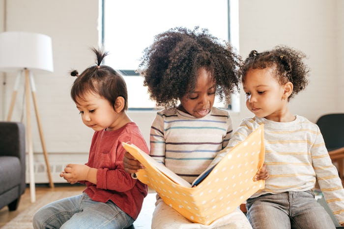 three kids reading a book