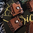 Brownies made to look like the book from 'Hocus Pocus' sit on a black plate. 