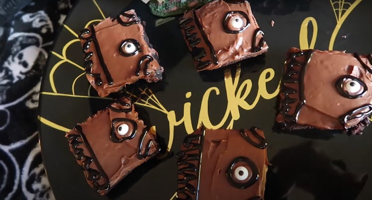 Brownies made to look like the book from 'Hocus Pocus' sit on a black plate.