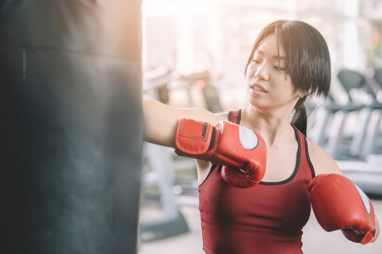 Young female athlete wearing boxing gloves workout