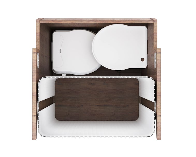 A removable toilet seat can be seen in white color. It is compact and surrounded by what appears to ...