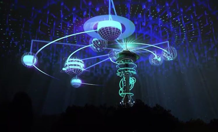 The Space Needle in Seattle is lit up with colorful lights at night.