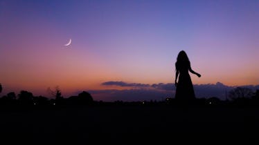 Young woman looking up at crescent moon