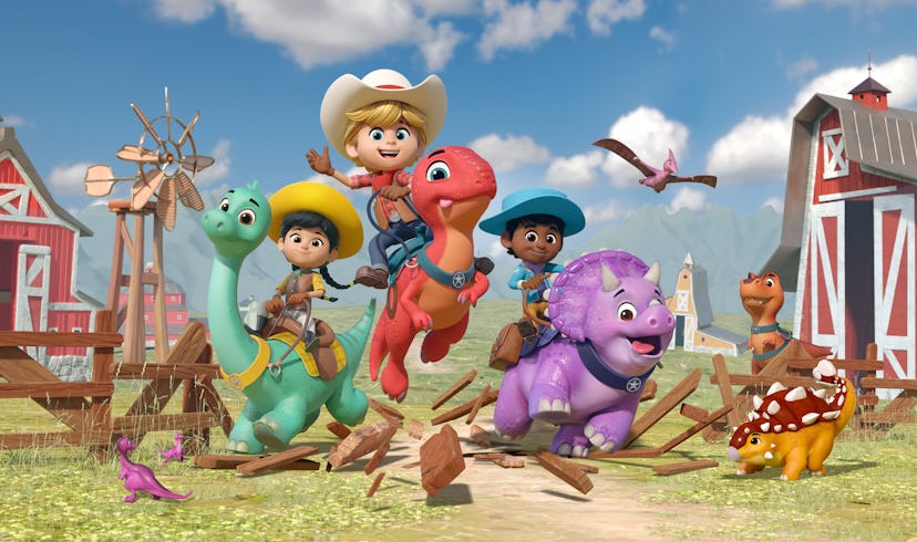 Children dressed as cowboys and cowgirls ride on the backs of colorful, friendly, cartoon dinosaurs.