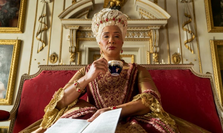 Queen Charlotte sips a cup of tea while sitting on her throne in 'Bridgerton.'