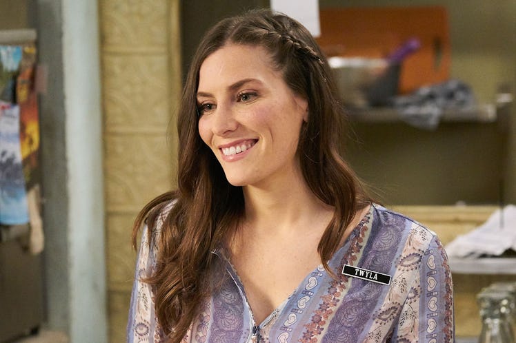 Twyla from 'Schitt's Creek' stands behind the counter at Café Tropical.