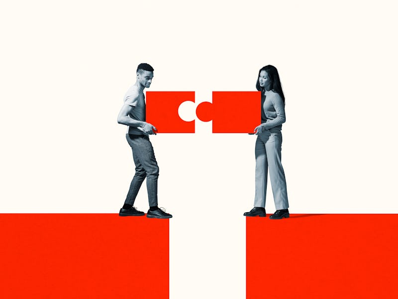 Young man and woman positioning orange puzzle pieces while standing at the edge of cliff against whi...