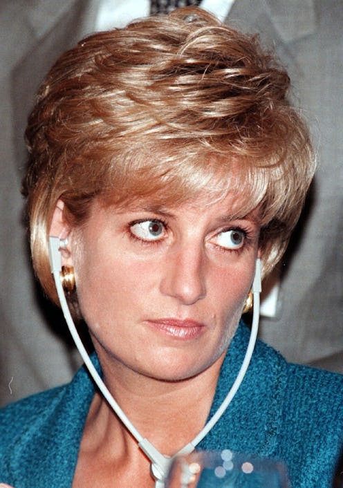 Diana wearing headphones with an unamused look on her face. She's wearing a teal blue jacket and her...