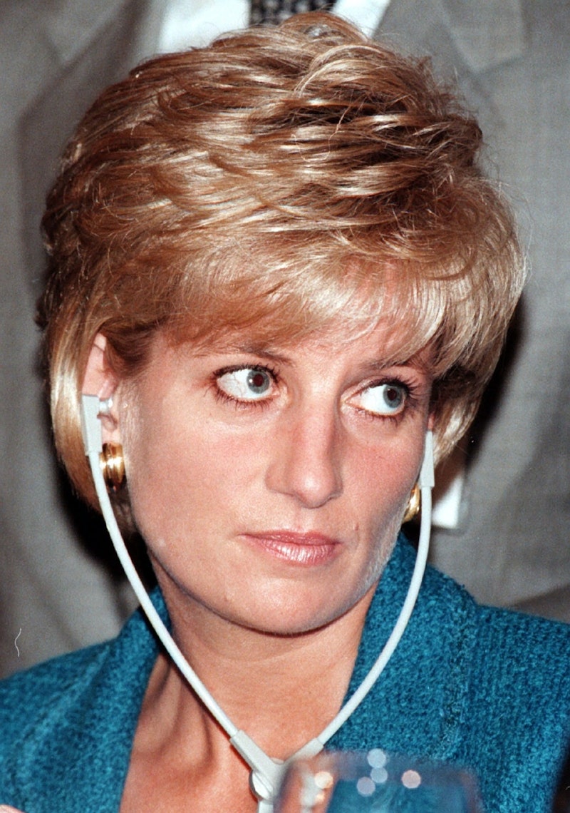 Diana wearing headphones with an unamused look on her face. She's wearing a teal blue jacket and her...