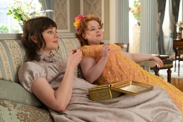 Eloise Bridgerton and Penelope Featherington sit on the couch together in 'Bridgerton.'