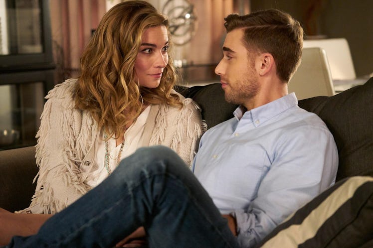 Alexis and Ted from 'Schitt's Creek' look at each other while sitting on a couch.