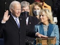Jill Biden holding up a large Bible while President Joe Biden recites the Presidential Oath.