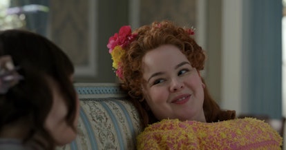 Penelope from "Bridgerton" smiles at Eloise on the couch.