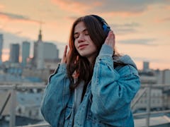 Young woman listening to music via headphones