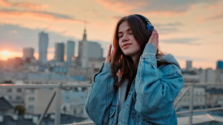 Young woman listening to music via headphones