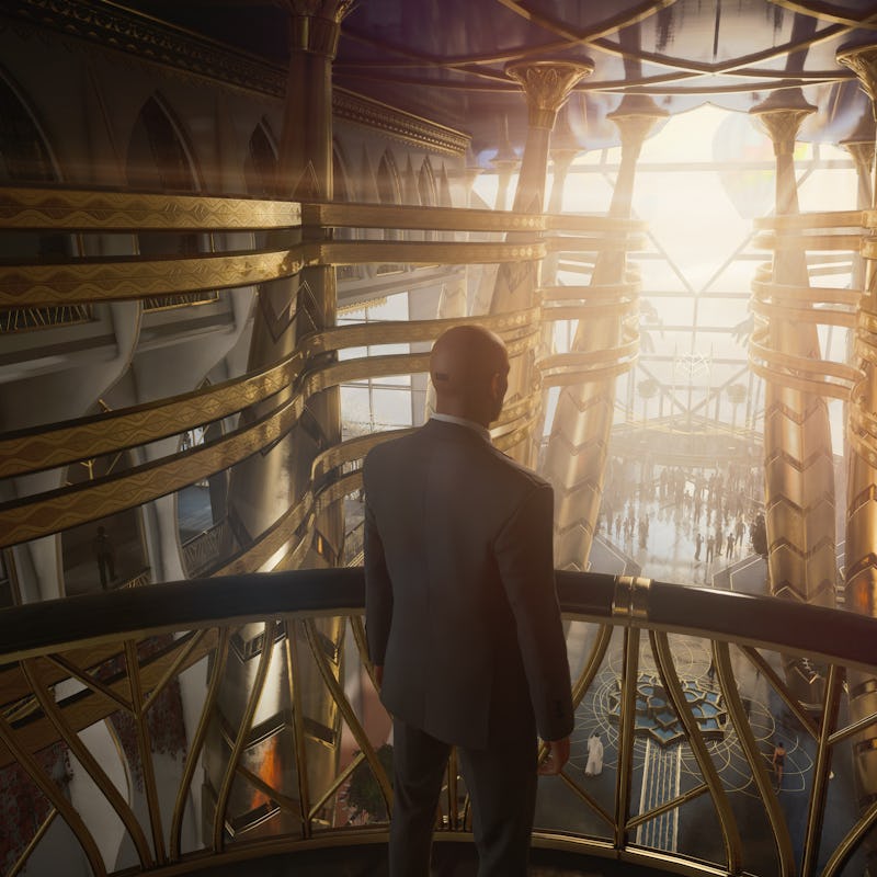 A screenshot from the game Hitman 3 featuring Agent 47 standing on a balcony and looking at a crowd