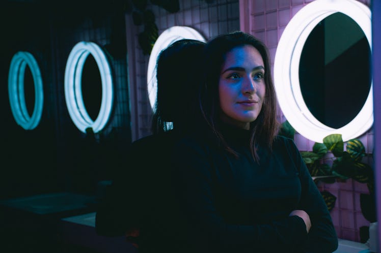 Smiling Young Woman Standing At Illuminated Bathroom