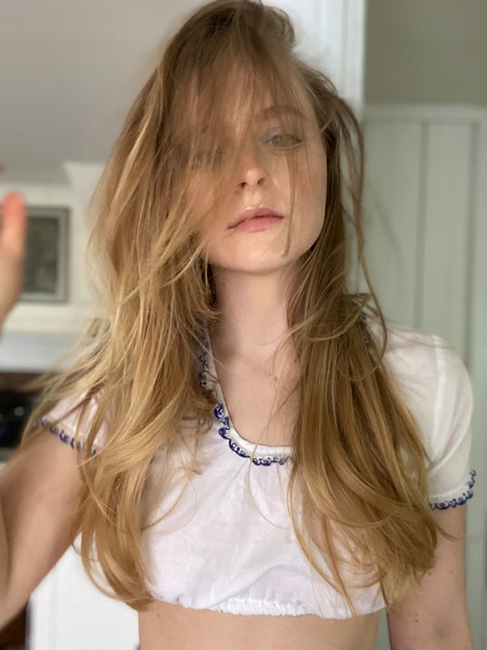 Anna Baryshnikov posing in a white linen crop top with blue embroidered edges