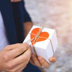 man holding a wrapped valentine's day gift