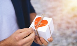 man holding a wrapped valentine's day gift