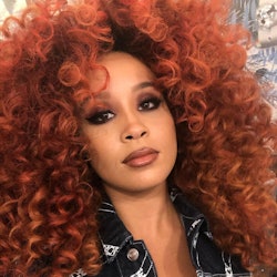 Jillian Hervey with a curly red hair posing for a photo