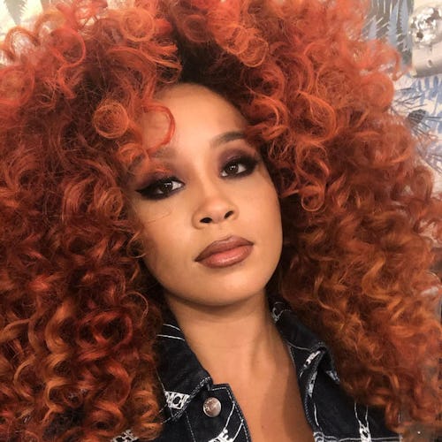 Jillian Hervey with a curly red hair posing for a photo